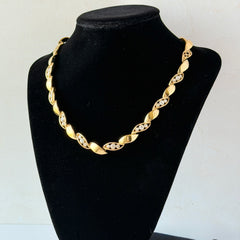Vintage Monet gold‑tone marquise link necklace with alternating polished and openwork rhinestone links, shown in various angles to highlight its bright finish, signed clasp, and 16½‑inch length.