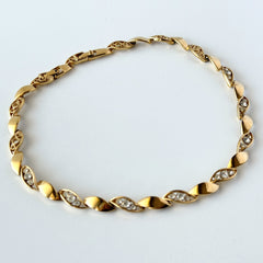 Vintage Monet gold‑tone marquise link necklace with alternating polished and openwork rhinestone links, shown in various angles to highlight its bright finish, signed clasp, and 16½‑inch length.