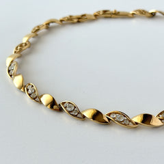 Vintage Monet gold‑tone marquise link necklace with alternating polished and openwork rhinestone links, shown in various angles to highlight its bright finish, signed clasp, and 16½‑inch length.