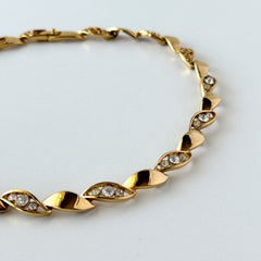 Vintage Monet gold‑tone marquise link necklace with alternating polished and openwork rhinestone links, shown in various angles to highlight its bright finish, signed clasp, and 16½‑inch length.