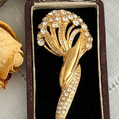 Vintage Monet gold tone brooch with pave rhinestones in a stylized floral umbel design.