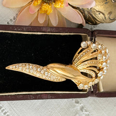 Vintage Monet gold tone brooch with pave rhinestones in a stylized floral umbel design.