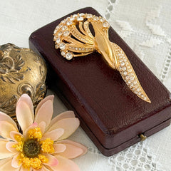 Vintage Monet gold tone brooch with pave rhinestones in a stylized floral umbel design.