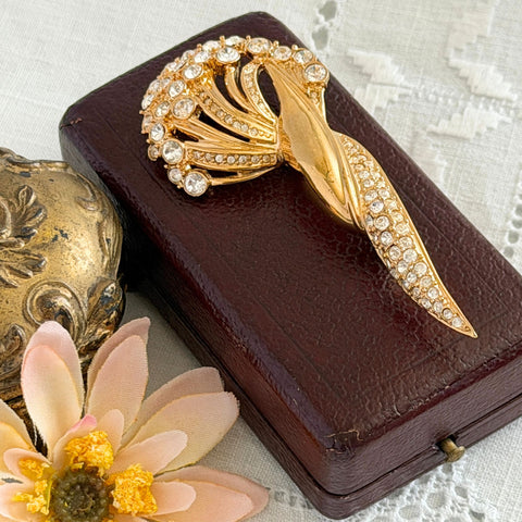 Vintage Monet gold tone brooch with pave rhinestones in a stylized floral umbel design.