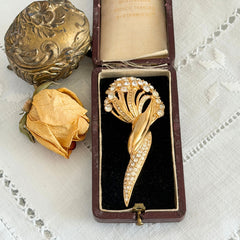 Vintage Monet gold tone brooch with pave rhinestones in a stylized floral umbel design.