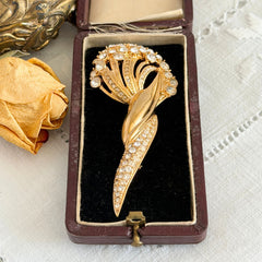 Vintage Monet gold tone brooch with pave rhinestones in a stylized floral umbel design.