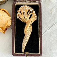 Vintage Monet gold tone brooch with pave rhinestones in a stylized floral umbel design.