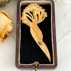 Vintage Monet gold tone brooch with pave rhinestones in a stylized floral umbel design.