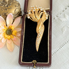 Vintage Monet gold tone brooch with pave rhinestones in a stylized floral umbel design.