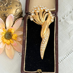 Vintage Monet gold tone brooch with pave rhinestones in a stylized floral umbel design.