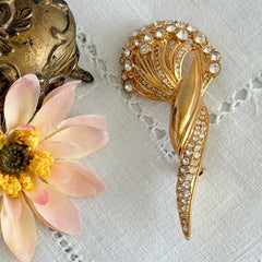 Vintage Monet gold tone brooch with pave rhinestones in a stylized floral umbel design.