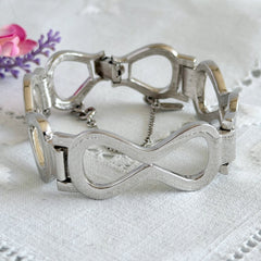 Vintage Monet silver‑tone infinity link bracelet with polished modernist links and signed clasp.