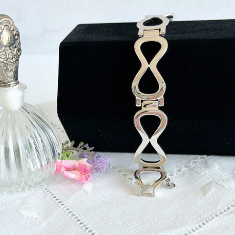 Vintage Monet silver‑tone infinity link bracelet with polished modernist links and signed clasp.