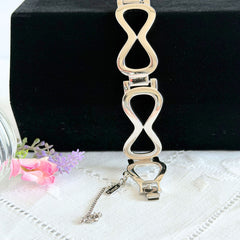 Vintage Monet silver‑tone infinity link bracelet with polished modernist links and signed clasp.
