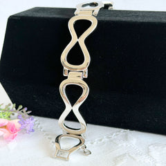 Vintage Monet silver‑tone infinity link bracelet with polished modernist links and signed clasp.