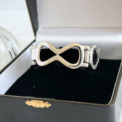 Vintage Monet silver‑tone infinity link bracelet with polished modernist links and signed clasp.