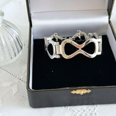 Vintage Monet silver‑tone infinity link bracelet with polished modernist links and signed clasp.