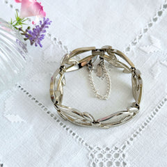 Vintage Monet modernist floral silver‑tone bracelet with sculptural polished links, signed clasp and © Monet hang tag