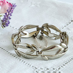 Vintage Monet modernist floral silver‑tone bracelet with sculptural polished links, signed clasp and © Monet hang tag