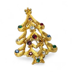 Vintage 1980s Monet Christmas tree brooch in textured gold tone with multicolor rhinestones, featuring curved branches, star topper, and signed back clasp—shown front and back to highlight design detail and maker’s mark.