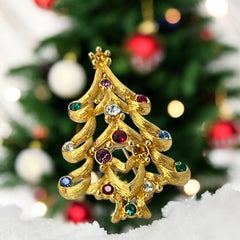 Vintage 1980s Monet Christmas tree brooch in textured gold tone with multicolor rhinestones, featuring curved branches, star topper, and signed back clasp—shown front and back to highlight design detail and maker’s mark.