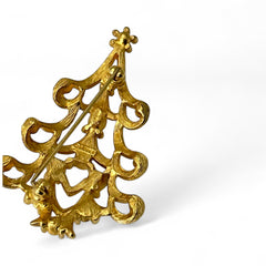 Vintage 1980s Monet Christmas tree brooch in textured gold tone with multicolor rhinestones, featuring curved branches, star topper, and signed back clasp—shown front and back to highlight design detail and maker’s mark.