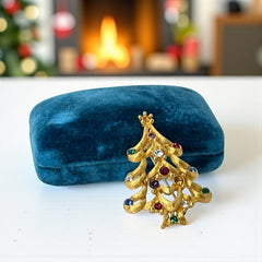 Vintage 1980s Monet Christmas tree brooch in textured gold tone with multicolor rhinestones, featuring curved branches, star topper, and signed back clasp—shown front and back to highlight design detail and maker’s mark.