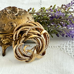 Vintage Monet textured gold tone swirl brooch with pave rhinestones, 1960s signed piece.
