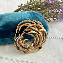 Vintage Monet textured gold tone swirl brooch with pave rhinestones, 1960s signed piece.