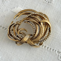 Vintage Monet textured gold tone swirl brooch with pave rhinestones, 1960s signed piece.
