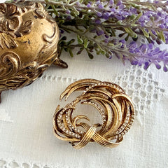 Vintage Monet textured gold tone swirl brooch with pave rhinestones, 1960s signed piece.