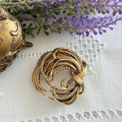 Vintage Monet textured gold tone swirl brooch with pave rhinestones, 1960s signed piece.