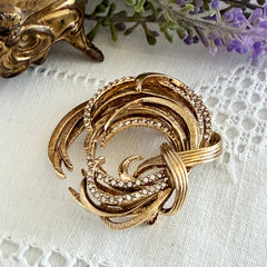 Vintage Monet textured gold tone swirl brooch with pave rhinestones, 1960s signed piece.