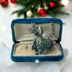 Vintage Monet angel brooch in silver tone metal with teal and light green enamel robe, clear rhinestone wings, and raised star detail; signed Monet on back.