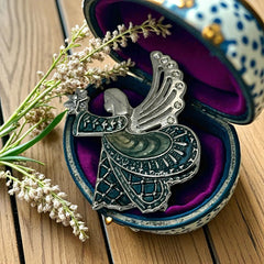 Vintage Monet angel brooch in silver tone metal with teal and light green enamel robe, clear rhinestone wings, and raised star detail; signed Monet on back.