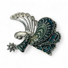 Vintage Monet angel brooch in silver tone metal with teal and light green enamel robe, clear rhinestone wings, and raised star detail; signed Monet on back.