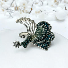 Vintage Monet angel brooch in silver tone metal with teal and light green enamel robe, clear rhinestone wings, and raised star detail; signed Monet on back.