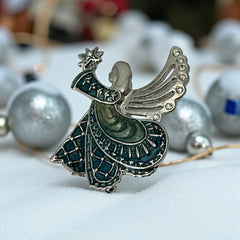 Vintage Monet angel brooch in silver tone metal with teal and light green enamel robe, clear rhinestone wings, and raised star detail; signed Monet on back.