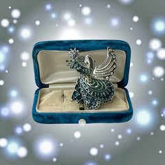 Vintage Monet angel brooch in silver tone metal with teal and light green enamel robe, clear rhinestone wings, and raised star detail; signed Monet on back.