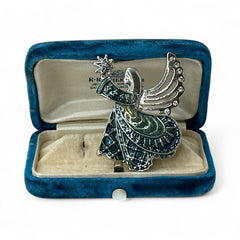 Vintage Monet angel brooch in silver tone metal with teal and light green enamel robe, clear rhinestone wings, and raised star detail; signed Monet on back.