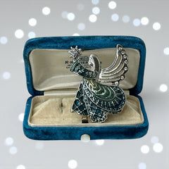 Vintage Monet angel brooch in silver tone metal with teal and light green enamel robe, clear rhinestone wings, and raised star detail; signed Monet on back.