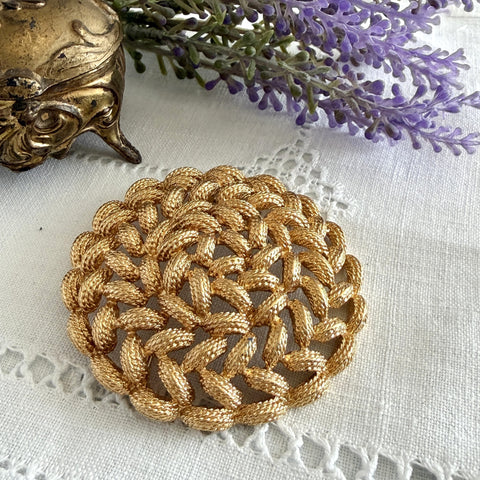 Vintage 1960s Monet braided gold‑tone rope brooch with textured sculptural design. Large 2¼" round statement pin in excellent condition, signed Monet.