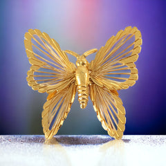 Vintage Monet gold‑tone butterfly brooch with openwork wire wings
