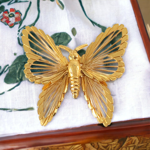 Vintage Monet gold‑tone butterfly brooch with openwork wire wings