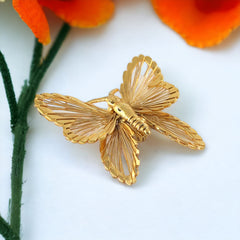 Vintage Monet gold‑tone butterfly brooch with openwork wire wings