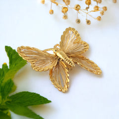 Vintage Monet gold‑tone butterfly brooch with openwork wire wings