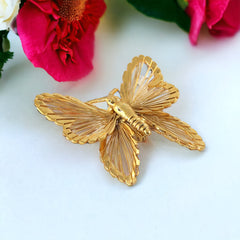 Vintage Monet gold‑tone butterfly brooch with openwork wire wings