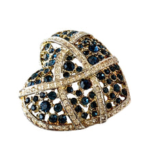 Vintage heart brooch with Montana sapphire and clear rhinestones in silver‑tone metal with gold wash, displayed on lace with a green book and pink flower