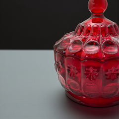 Vintage Moon and Stars ruby red glass candy dish with scalloped bowl and matching lid, featuring embossed celestial motifs and rich translucent color.