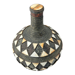 Vintage Moroccan pottery vase from the 1970s/80s, featuring a large clay body with ornate metal inlays, an antiqued bronze/brass finish, and three geometric rings of camel bone triangle patterns. Includes an original metal lid, reflecting its historic use for storing and transporting liquids. In very good vintage condition, showcasing intricate craftsmanship and cultural heritage.